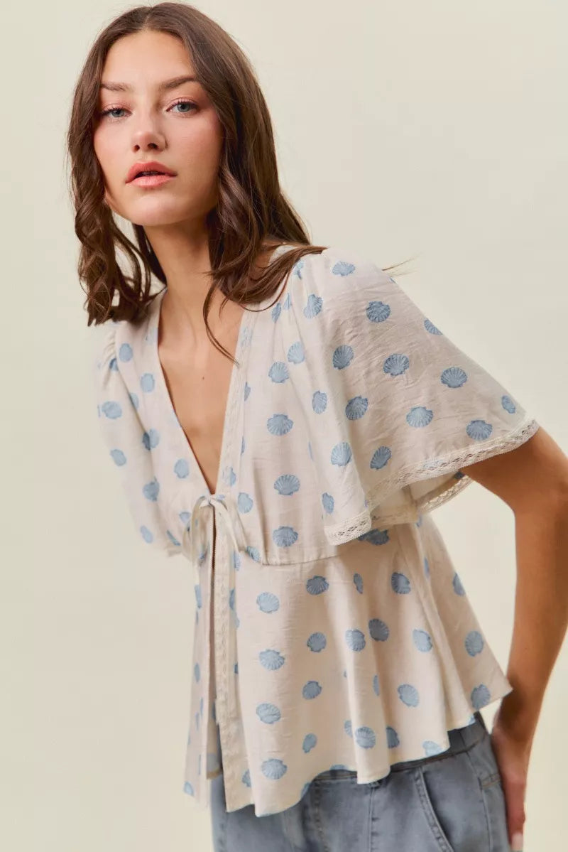 Ivory and blue shell print tie front flutter sleeve blouse detail view