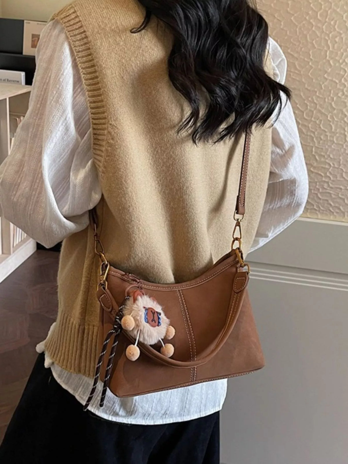 Model carrying caramel shoulder bag