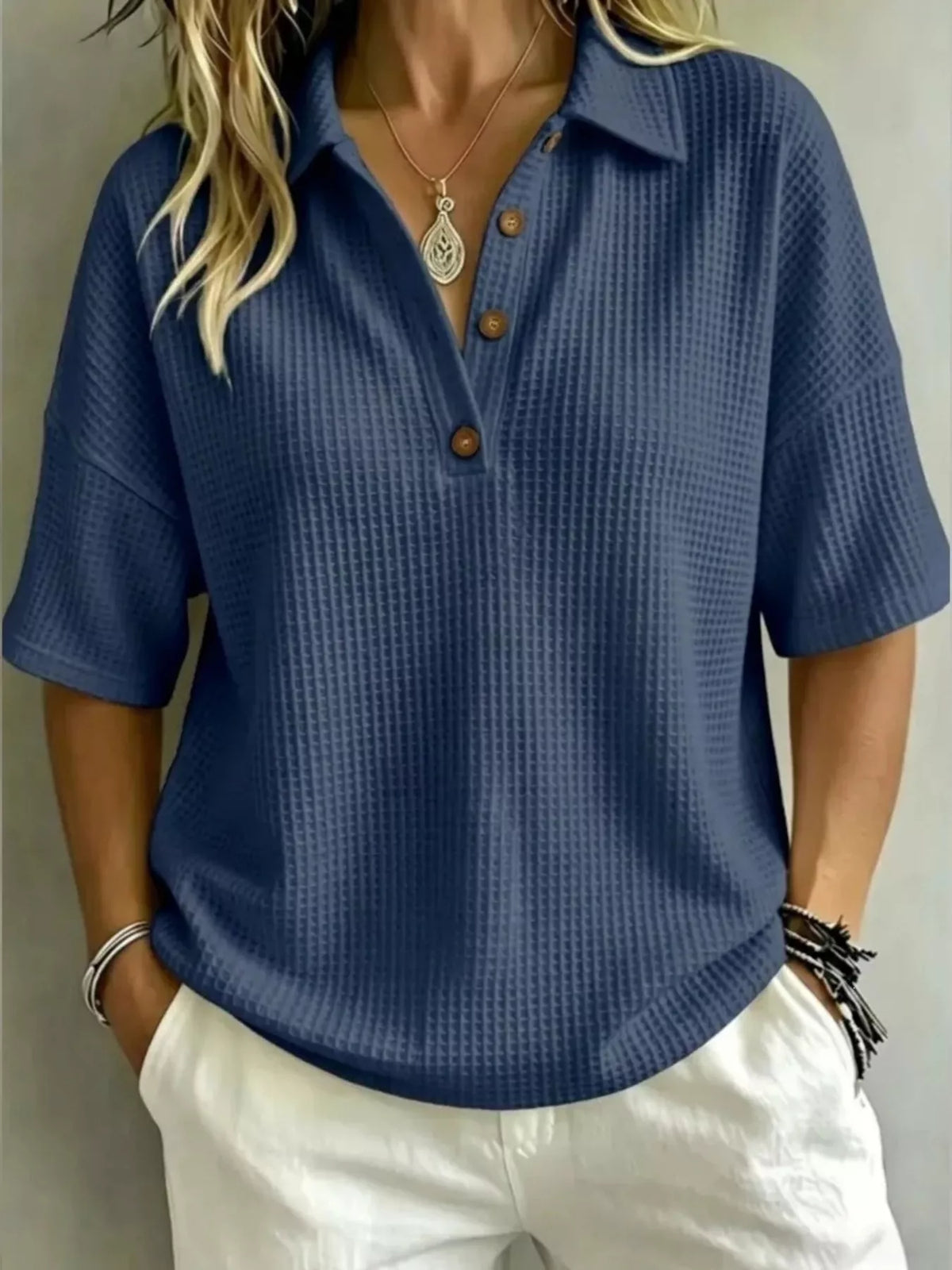 Waffle knit polo top in navy blue shown on a model