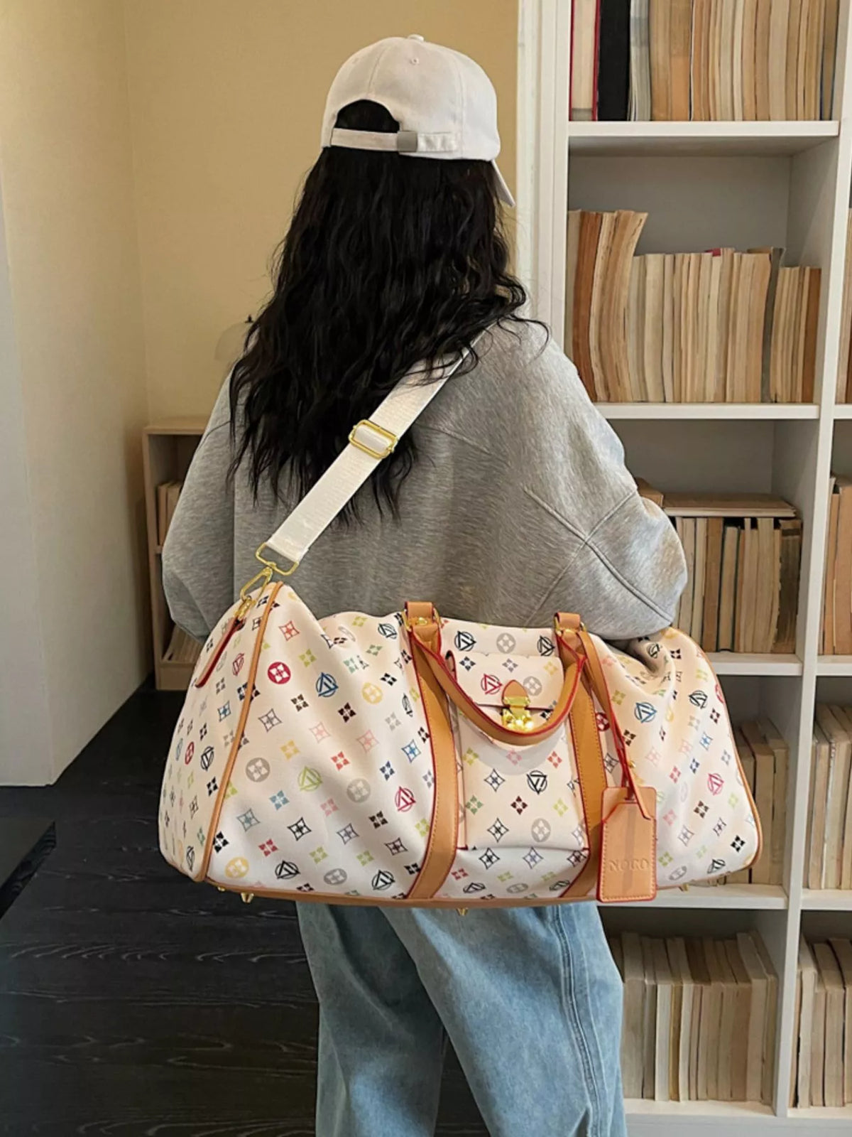 Cream printed PU leather travel duffel bag front view