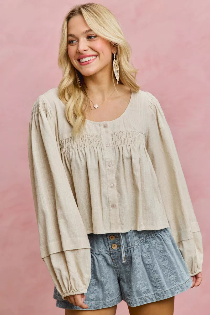 Cream linen blend smocked long sleeve top, angled view