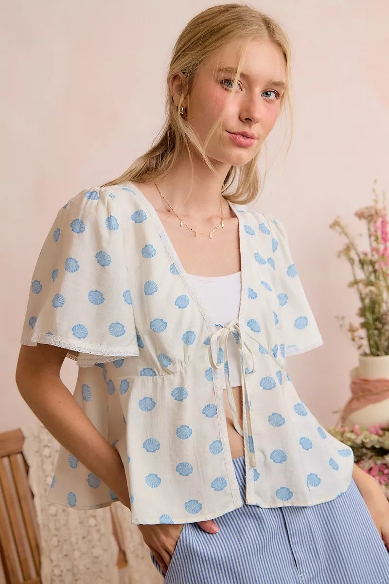 Ivory and blue shell print tie front flutter sleeve blouse back view