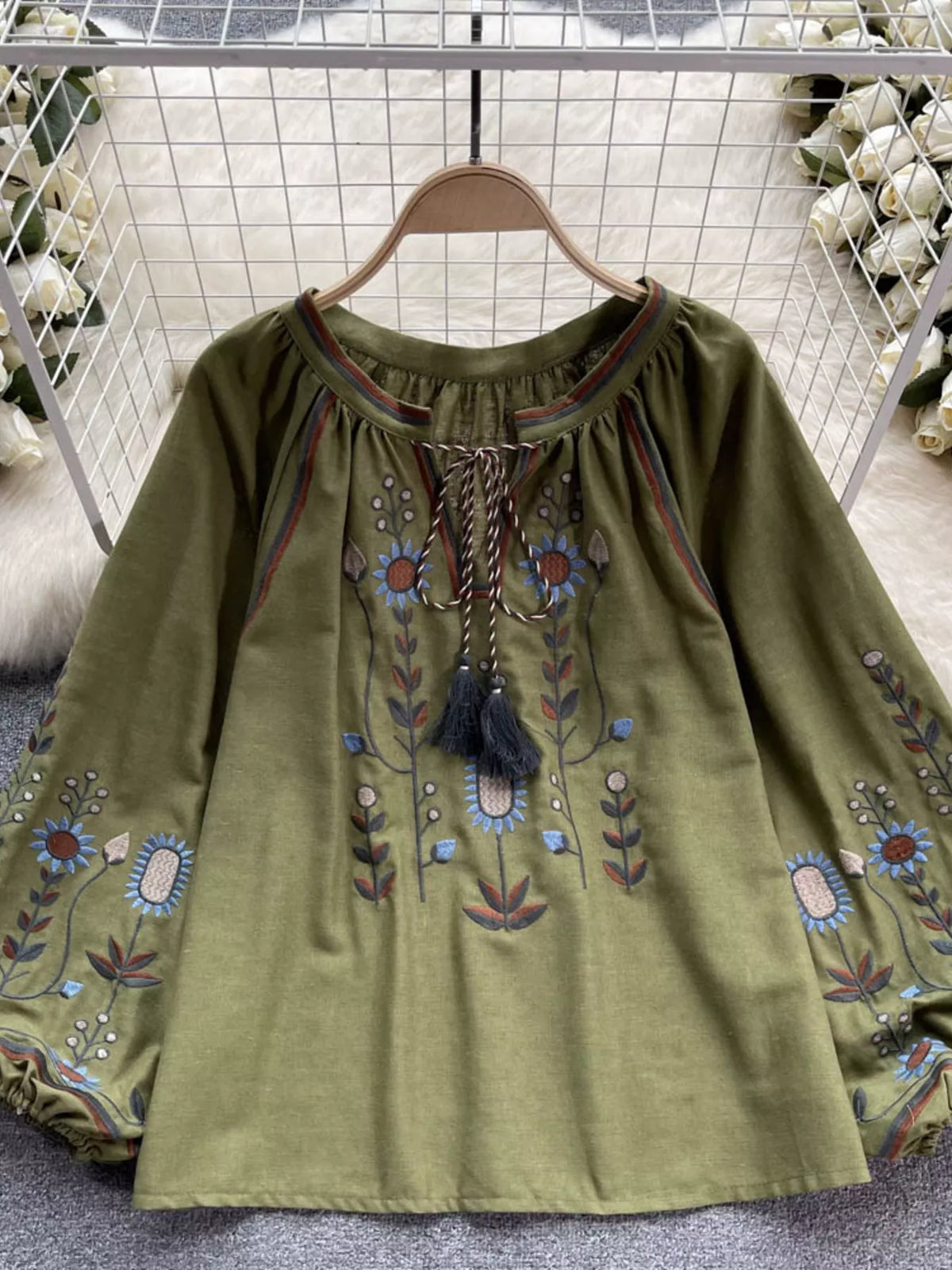 Embroidered tie neck blouse in green, front view
