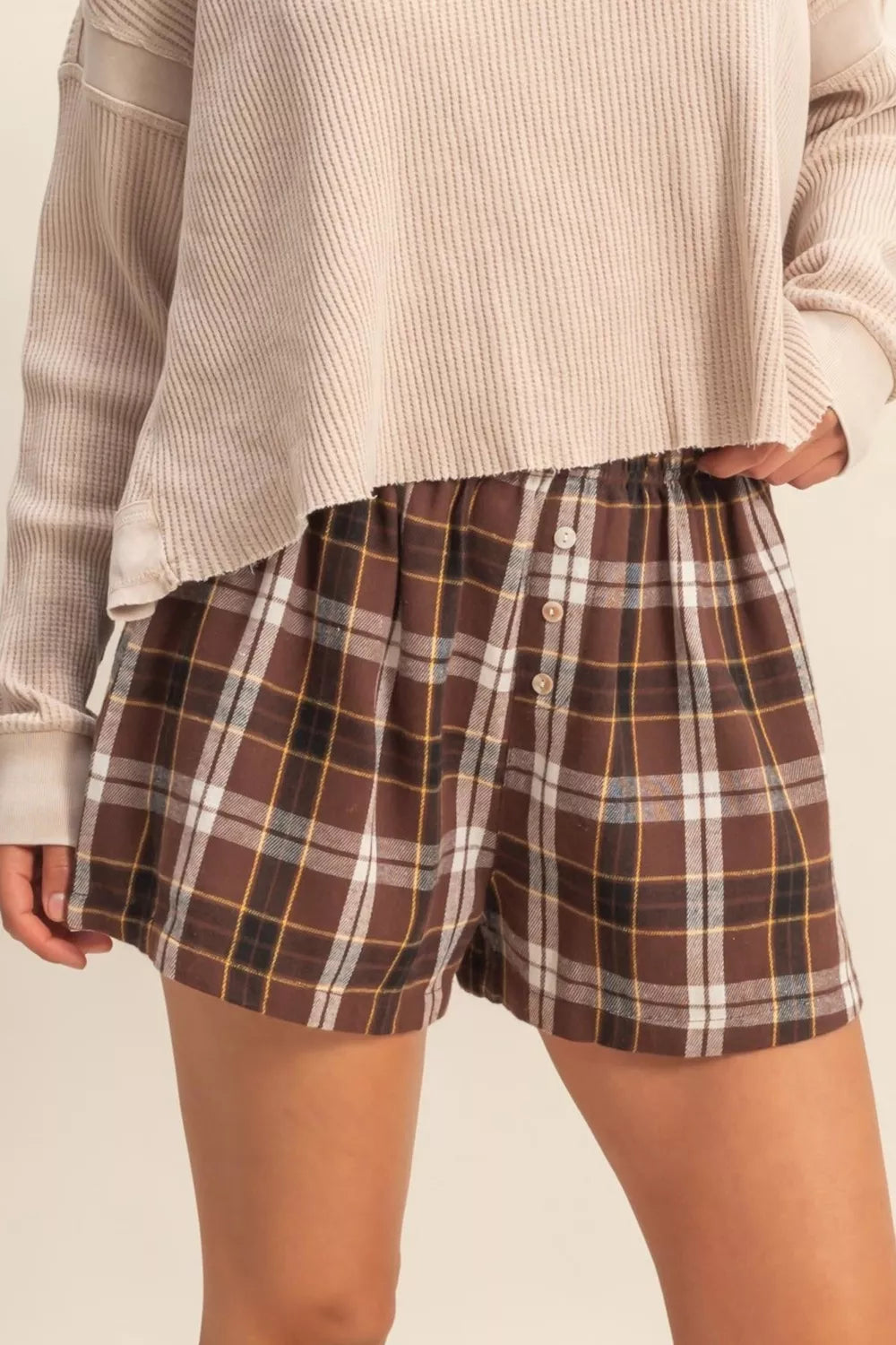 Button front detail on plaid burgundy shorts
