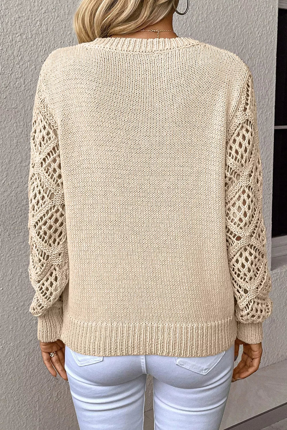 Cream knit sweater with openwork crochet sleeves styled with jeans