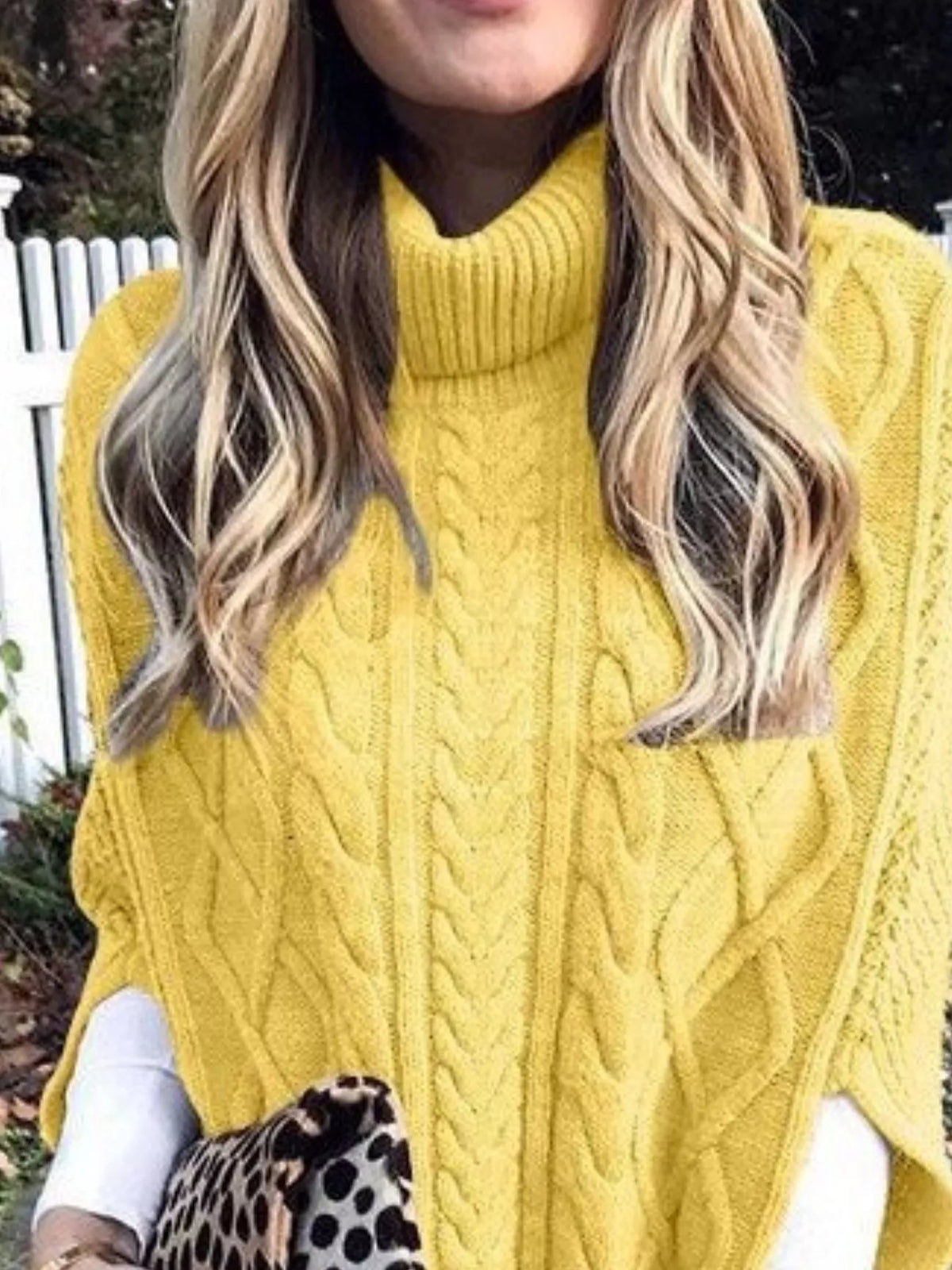 Chunky cable knit turtleneck poncho styled with denim