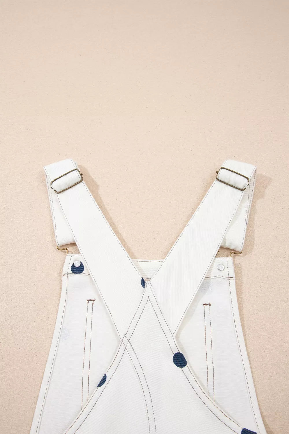 Denim jumpsuit strap and buckle detail