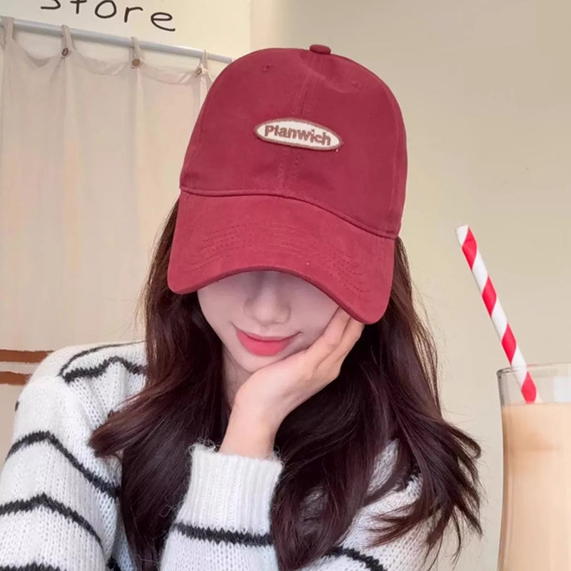 Cotton baseball cap with an embroidered oval patch on the front
