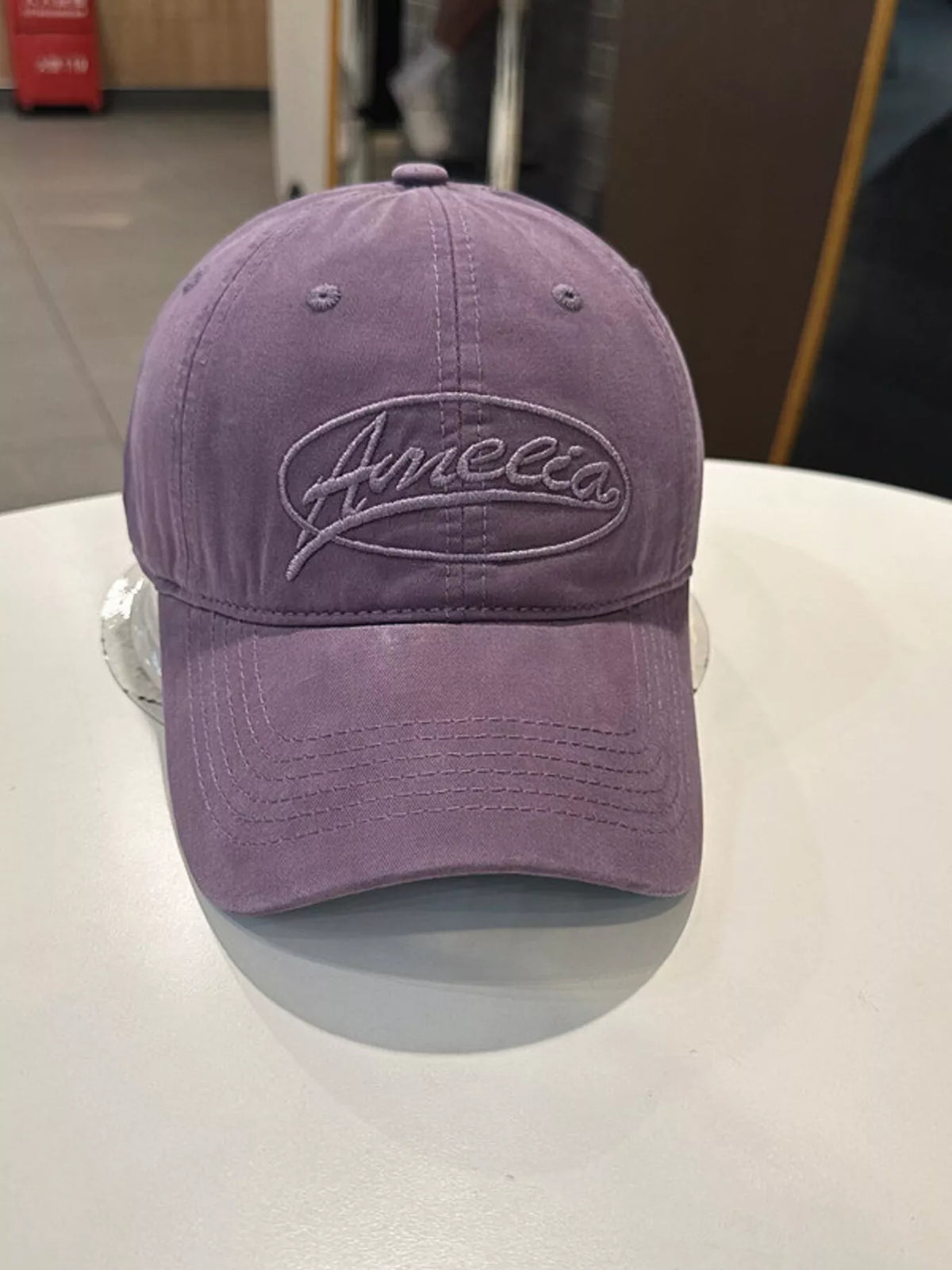 The embroidered cap shown in a neutral colorway