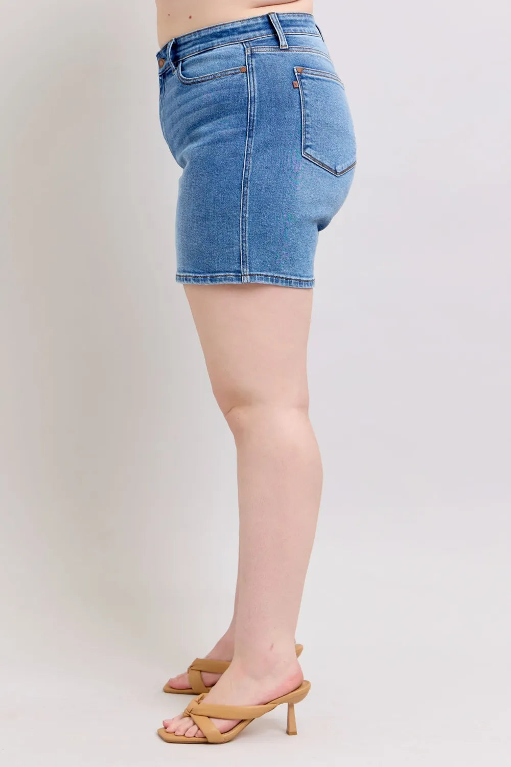 Medium wash denim shorts shown on a standing model