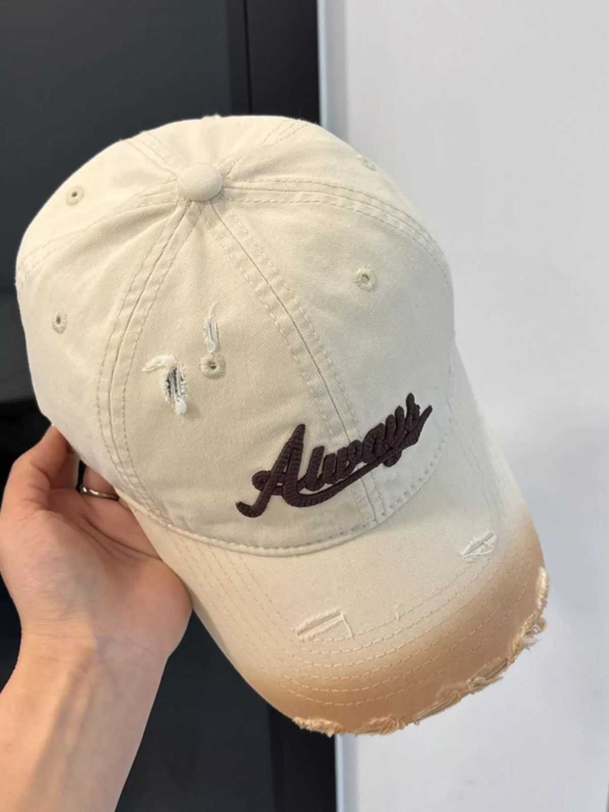Front view of the beige distressed baseball cap