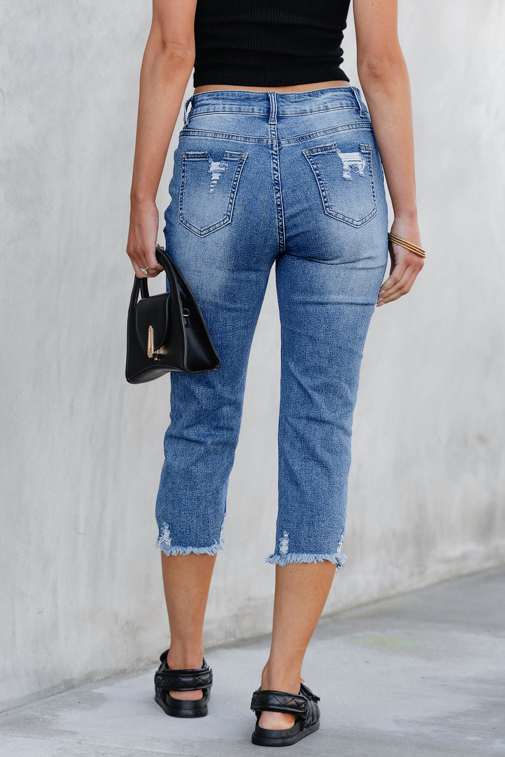 Distressed capri jeans side view showing skinny leg
