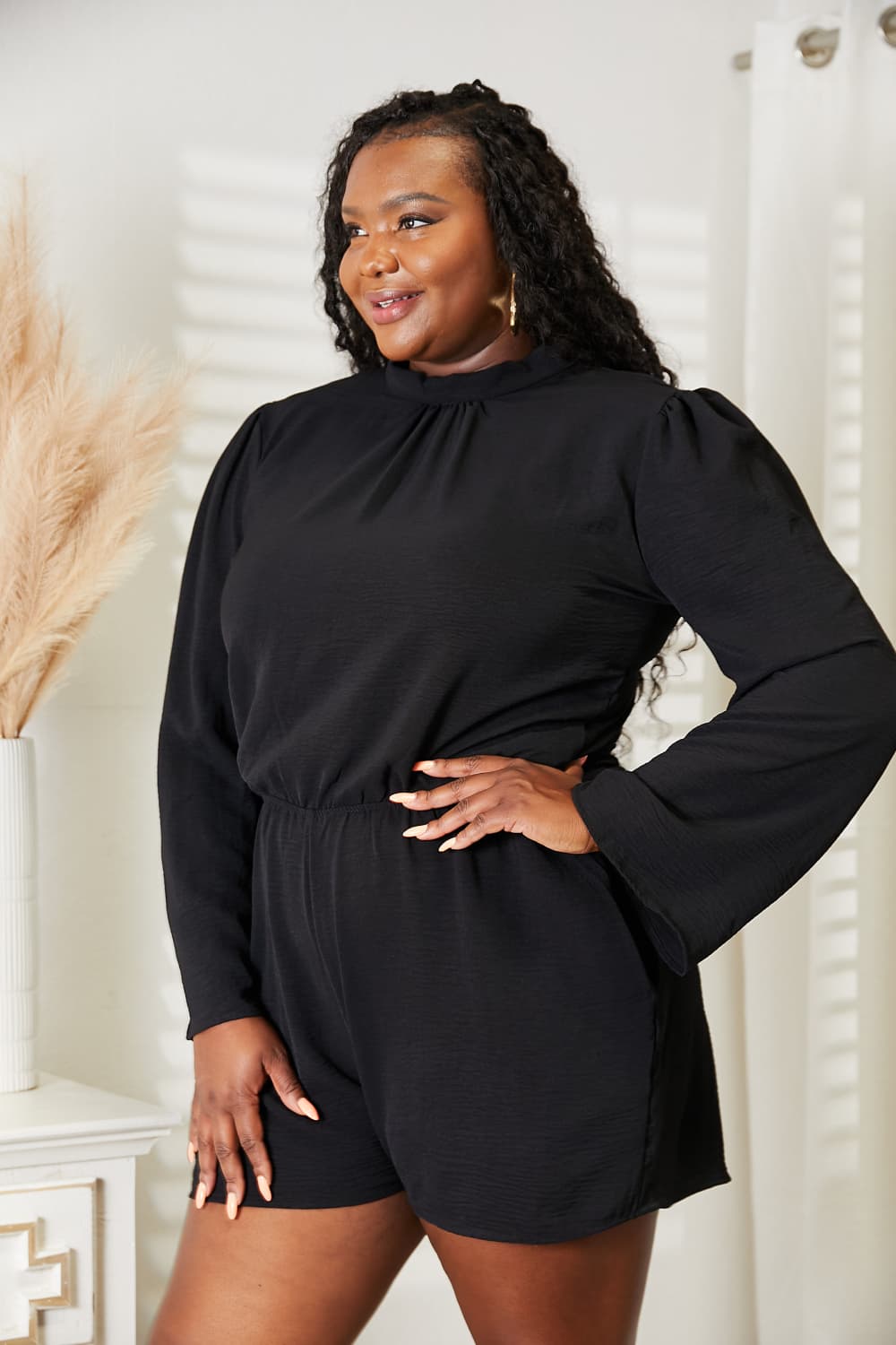 Side view of the black romper showing the open back detail
