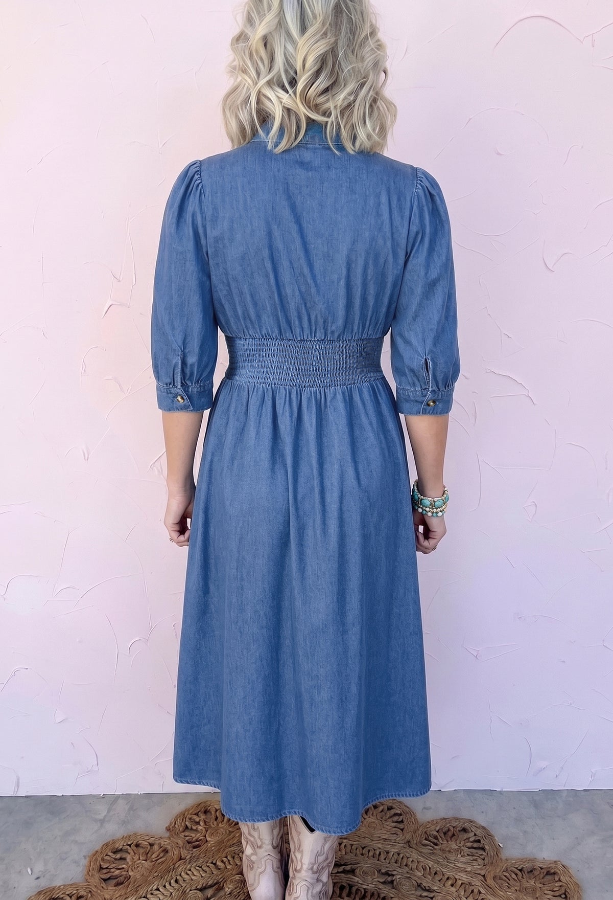 Back view of blue denim midi dress with puff sleeves
