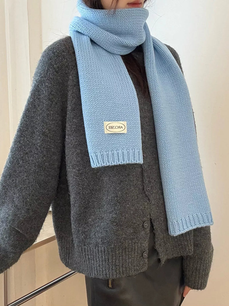 Solid color knitted winter scarf shown around the neck