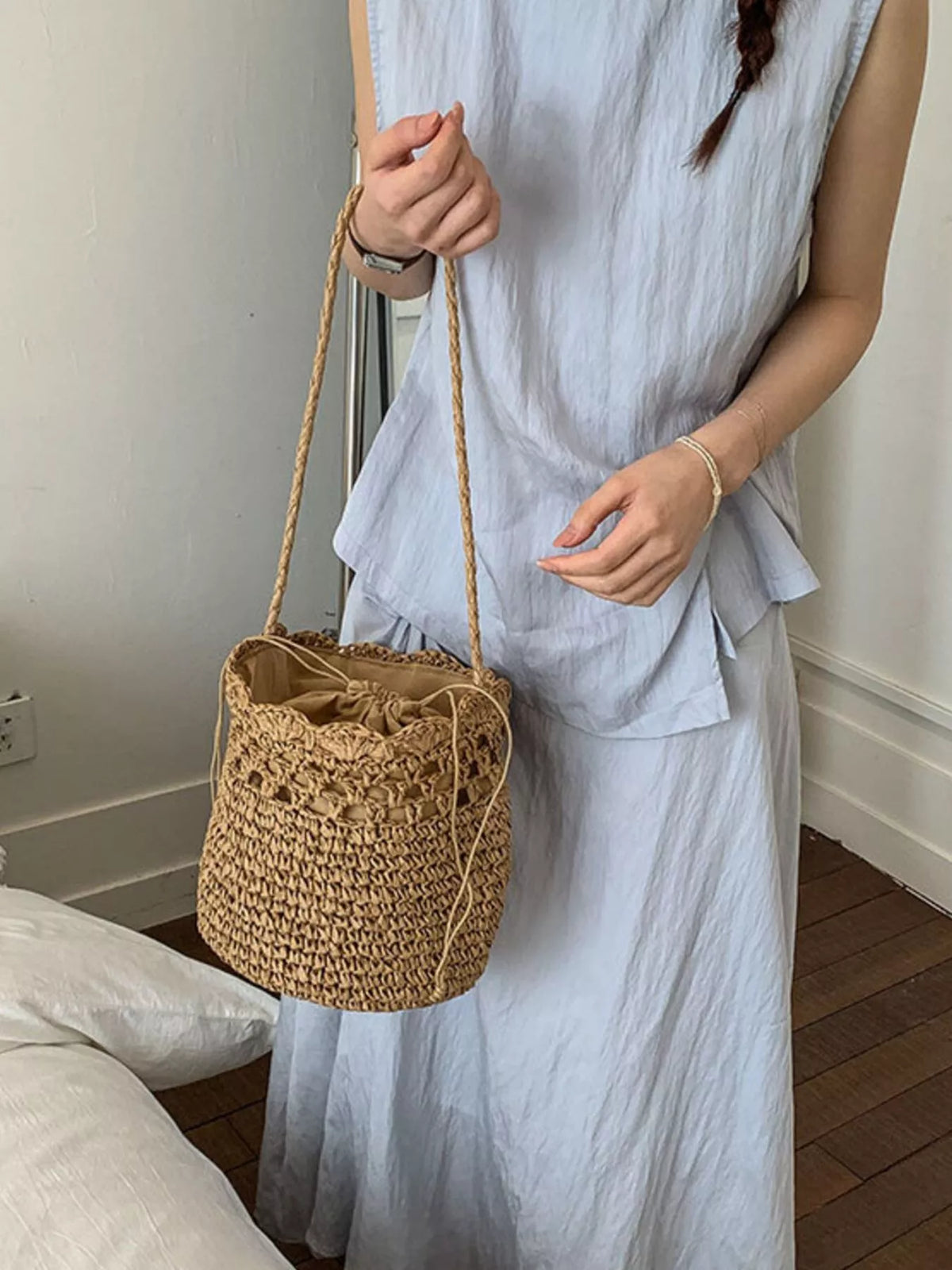 Straw bucket bag held by model