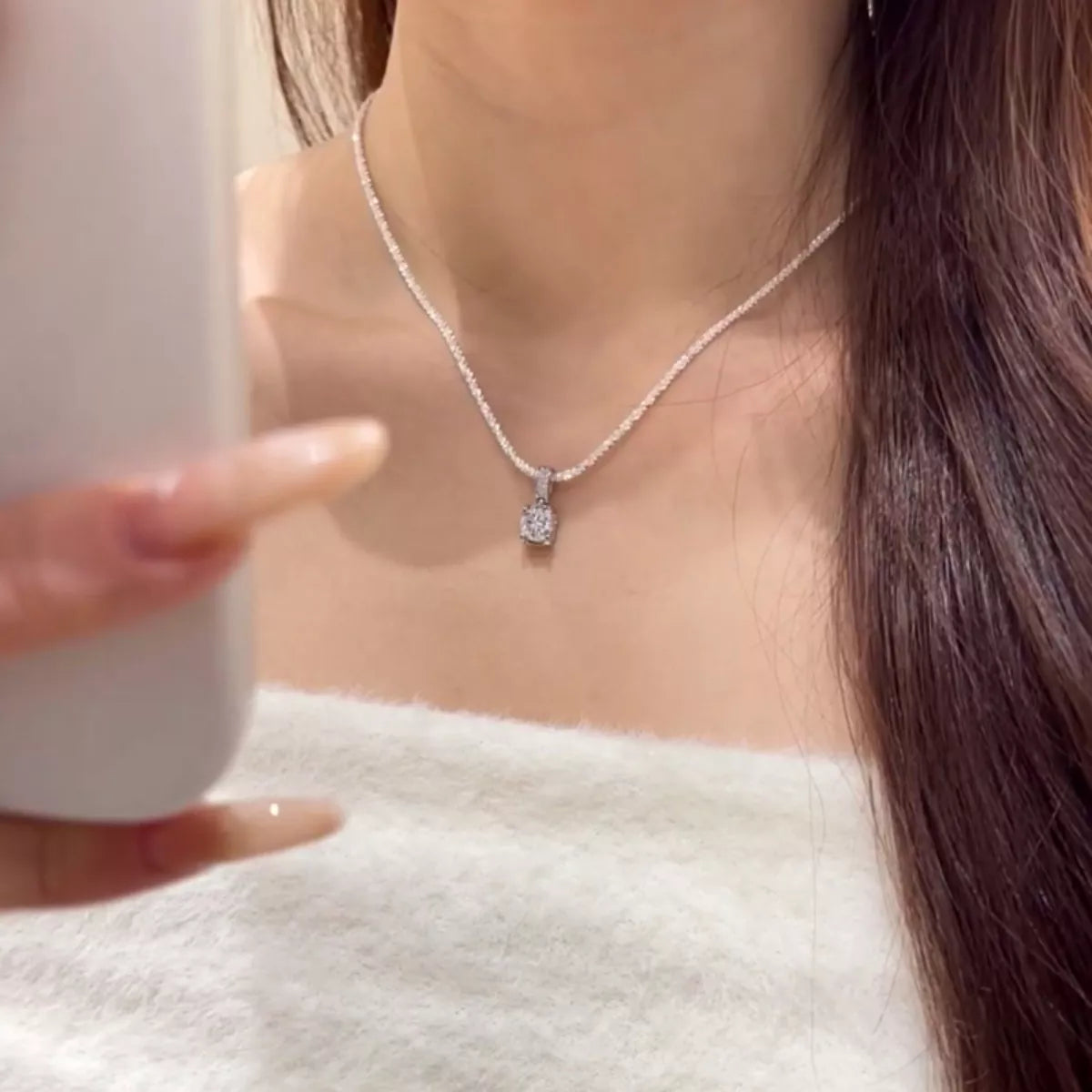Sterling silver moissanite necklace shown worn on the collarbone