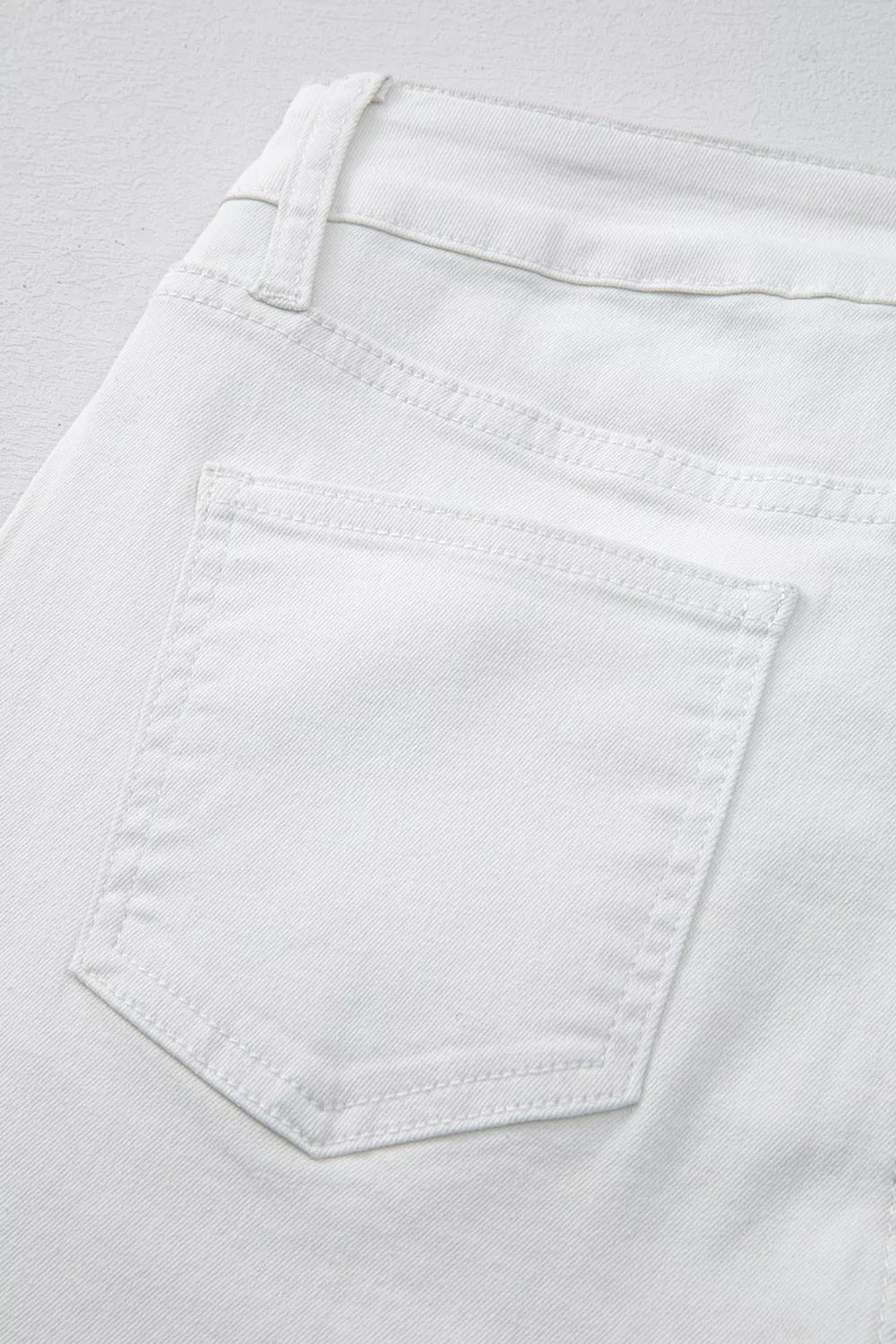 Close up of pocket on white straight leg jeans
