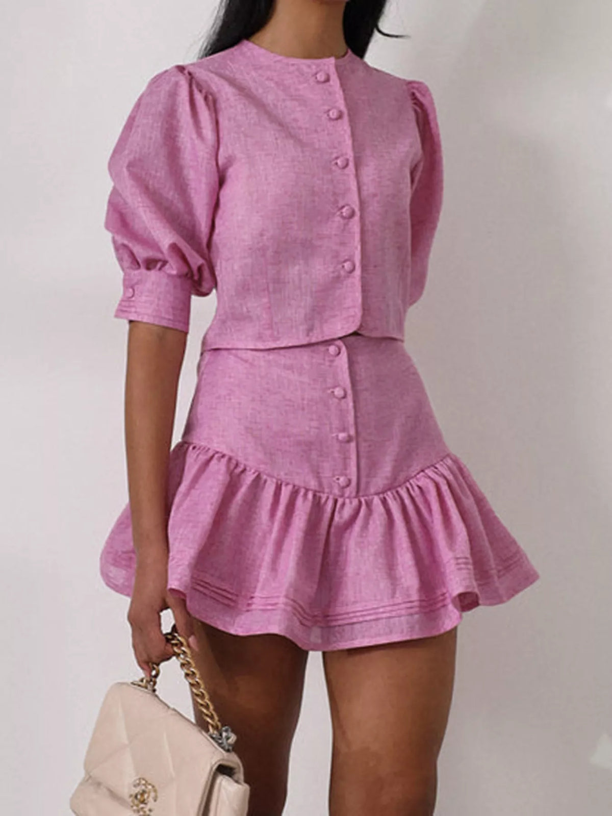 Fuchsia pink puff sleeve cropped top and ruffled skirt set side view