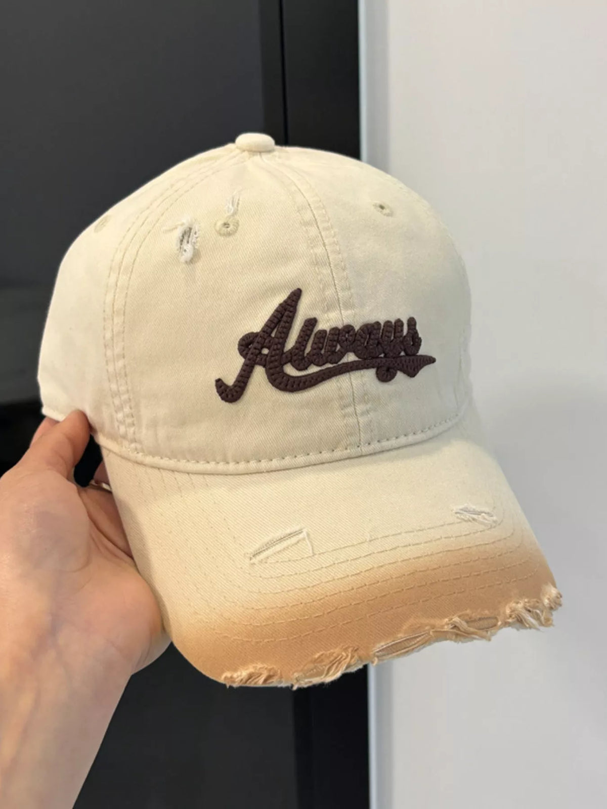 Embroidery detail on the beige cotton cap