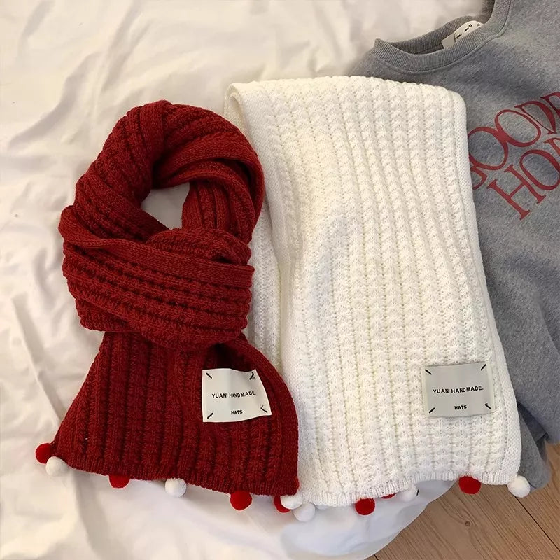 Handmade knitted pom-pom scarf around the neck