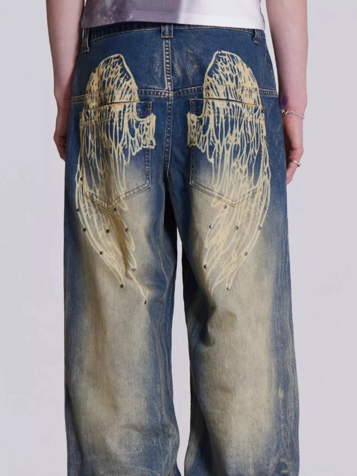Model wearing vintage wash studded jeans