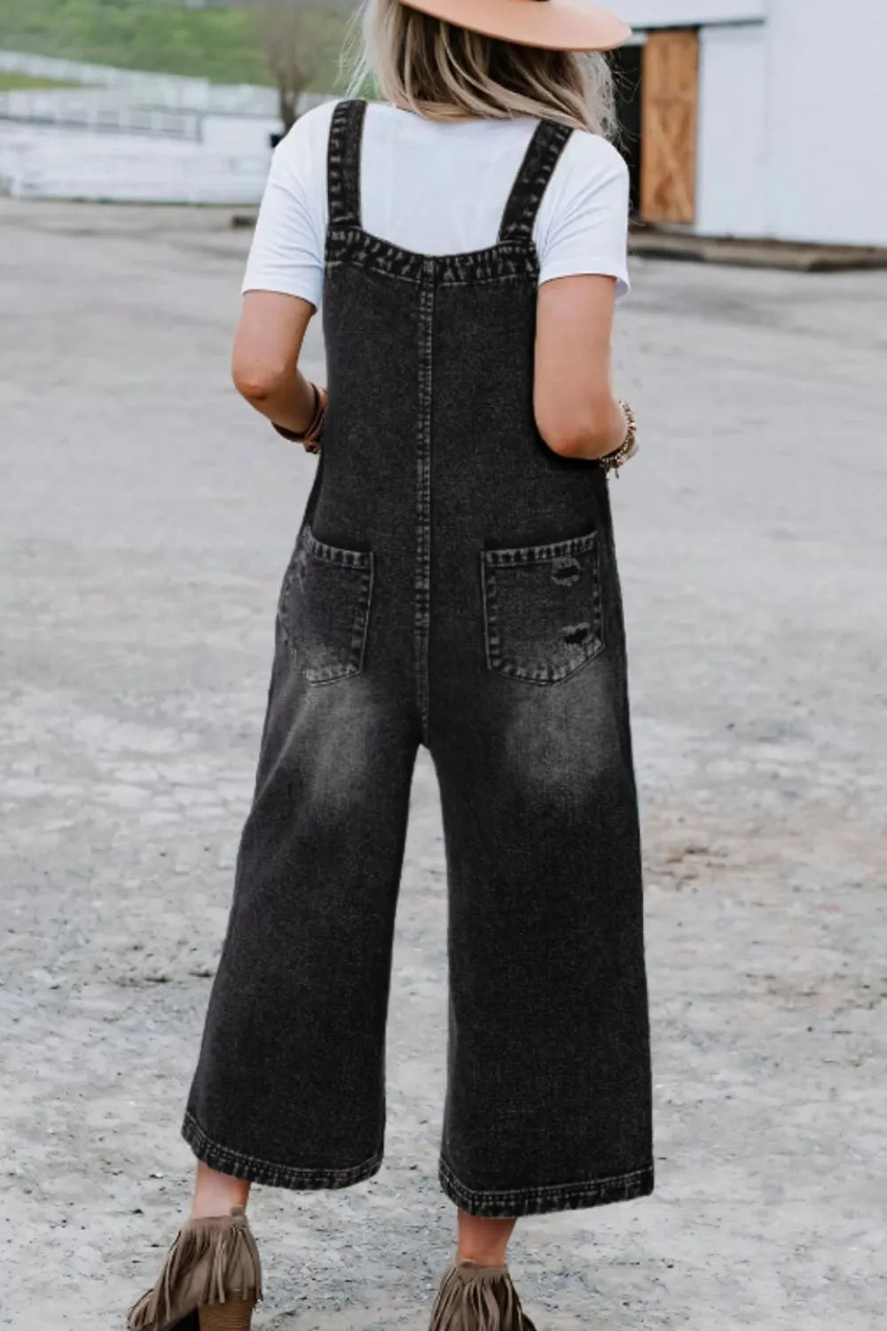 Black denim overalls distressed detail close up