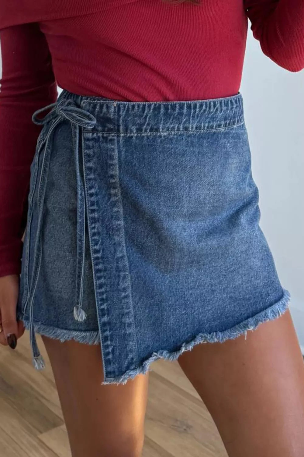 Medium wash wrapped tie waist denim skort detail view