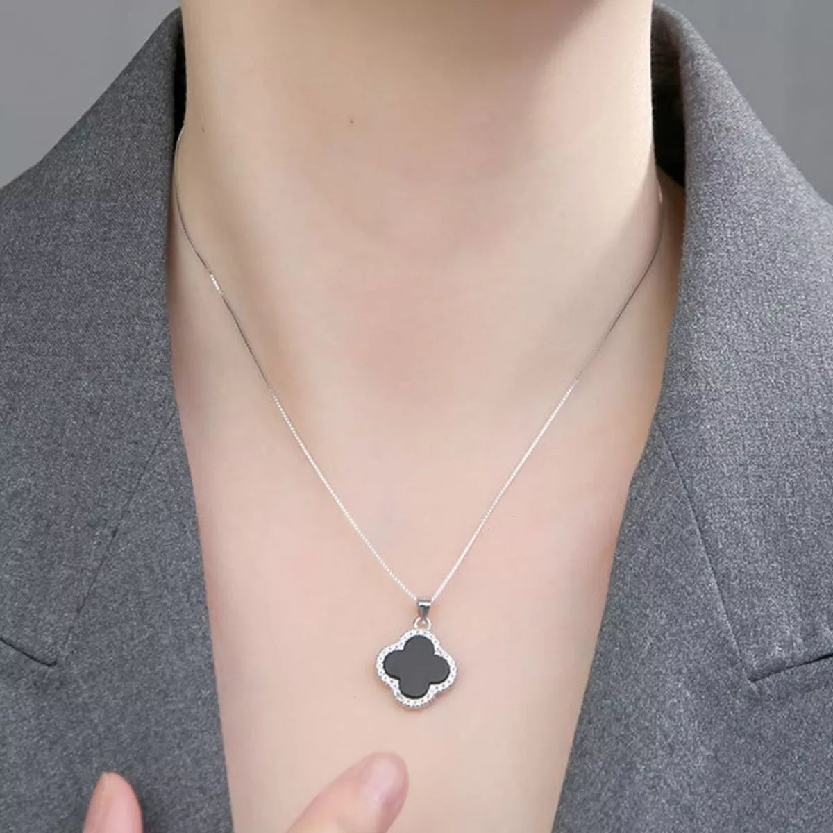 Four leaf clover pendant shown against a light surface