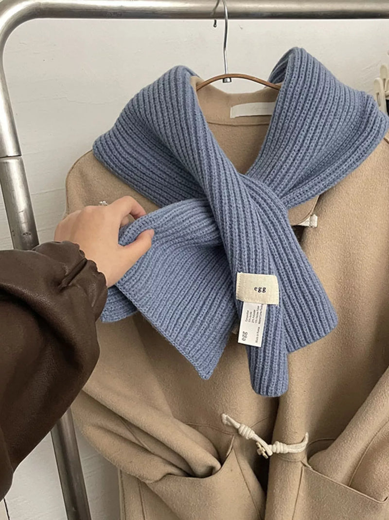Knitted ribbed scarf looped around the neck