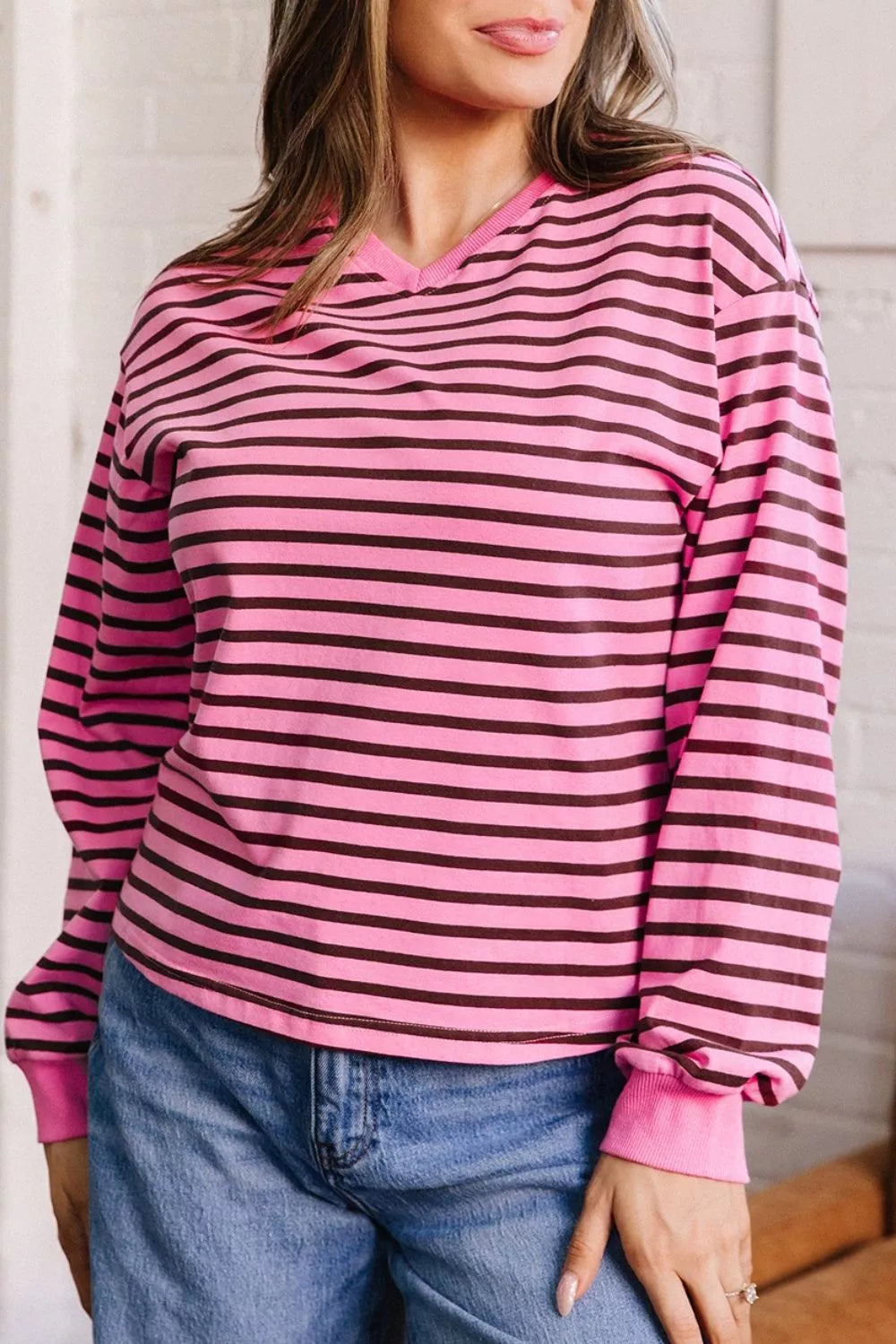 Fuchsia pink striped top styled with denim, front facing