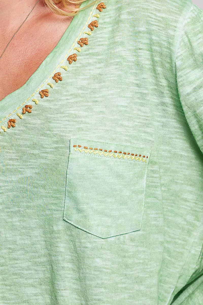 Cuff and sleeve detail on a green contrast stitch knit top