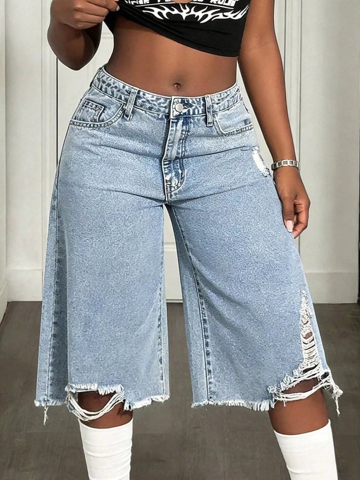 Side view of the distressed wide leg shorts showing the high waist