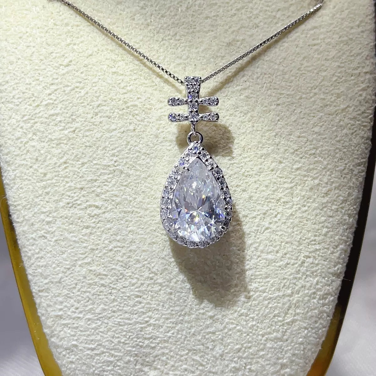 Moissanite pendant necklace shown worn on the collarbone