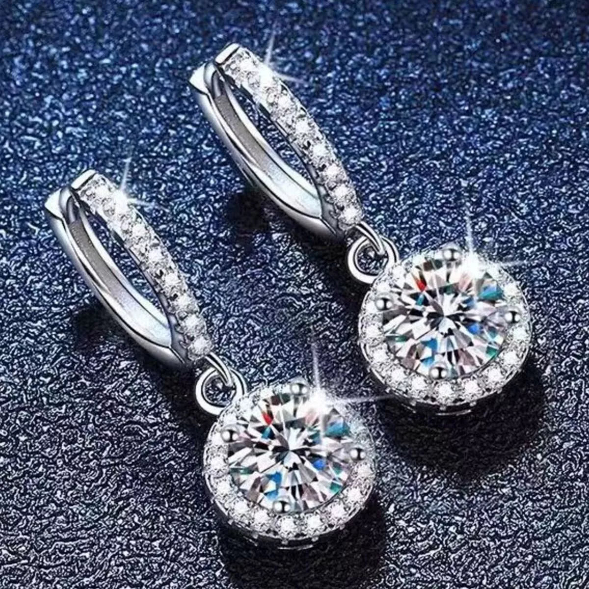 Moissanite earrings displayed with their matching box and bag