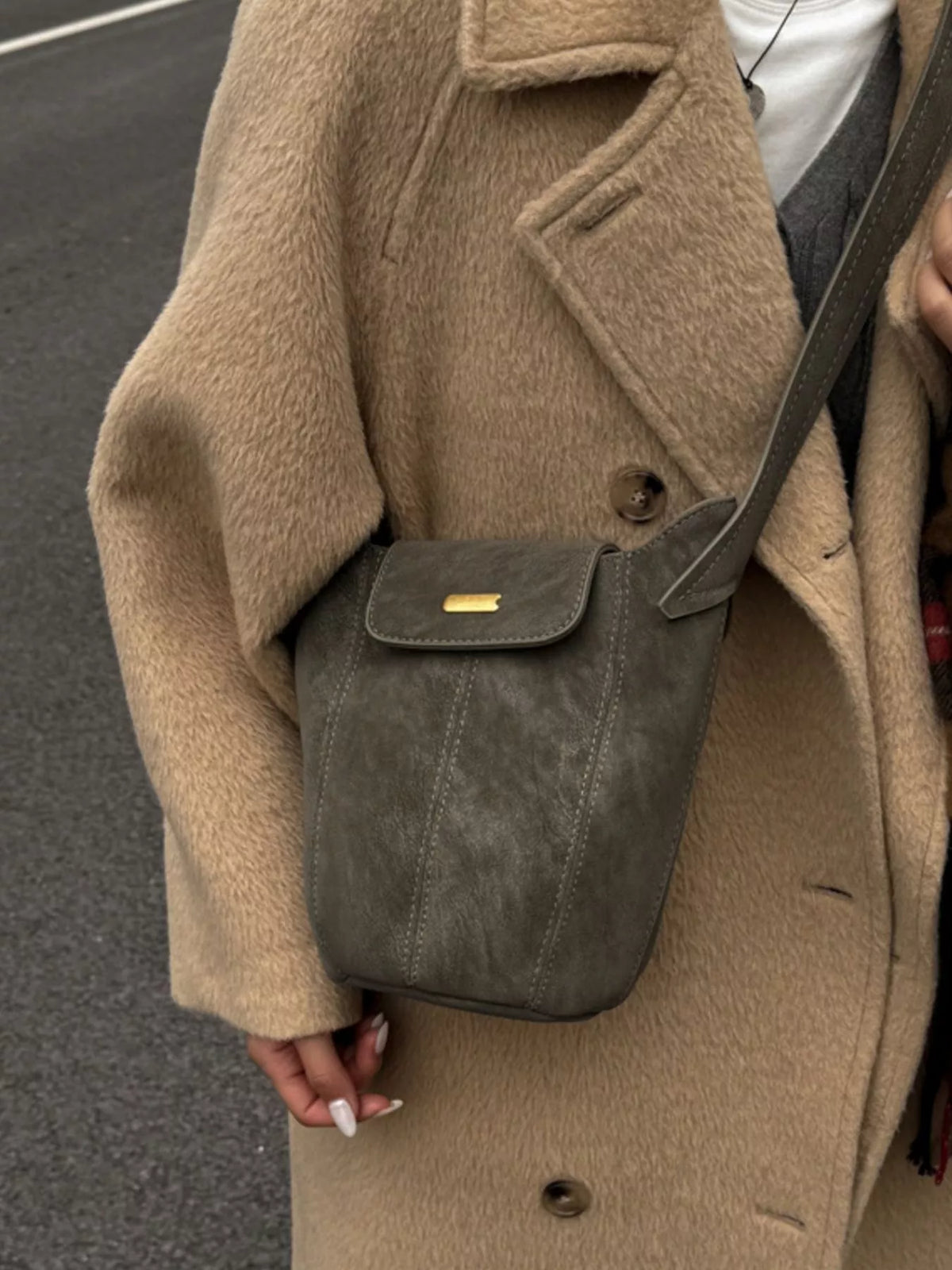 Green suede bucket bag carried on shoulder