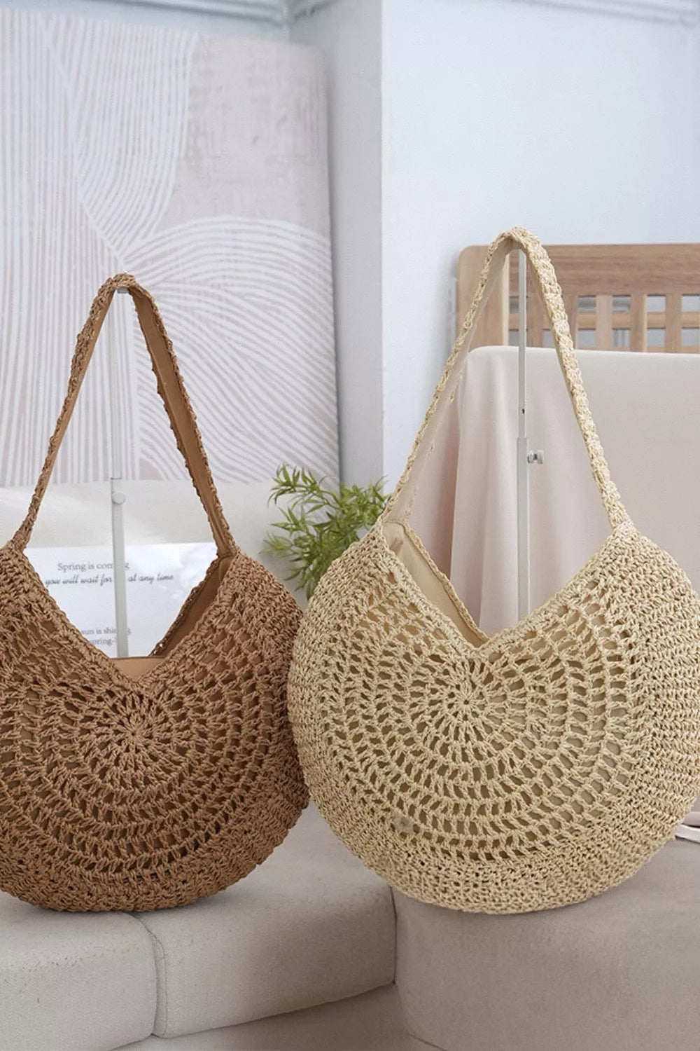 Round woven straw bag carried by model