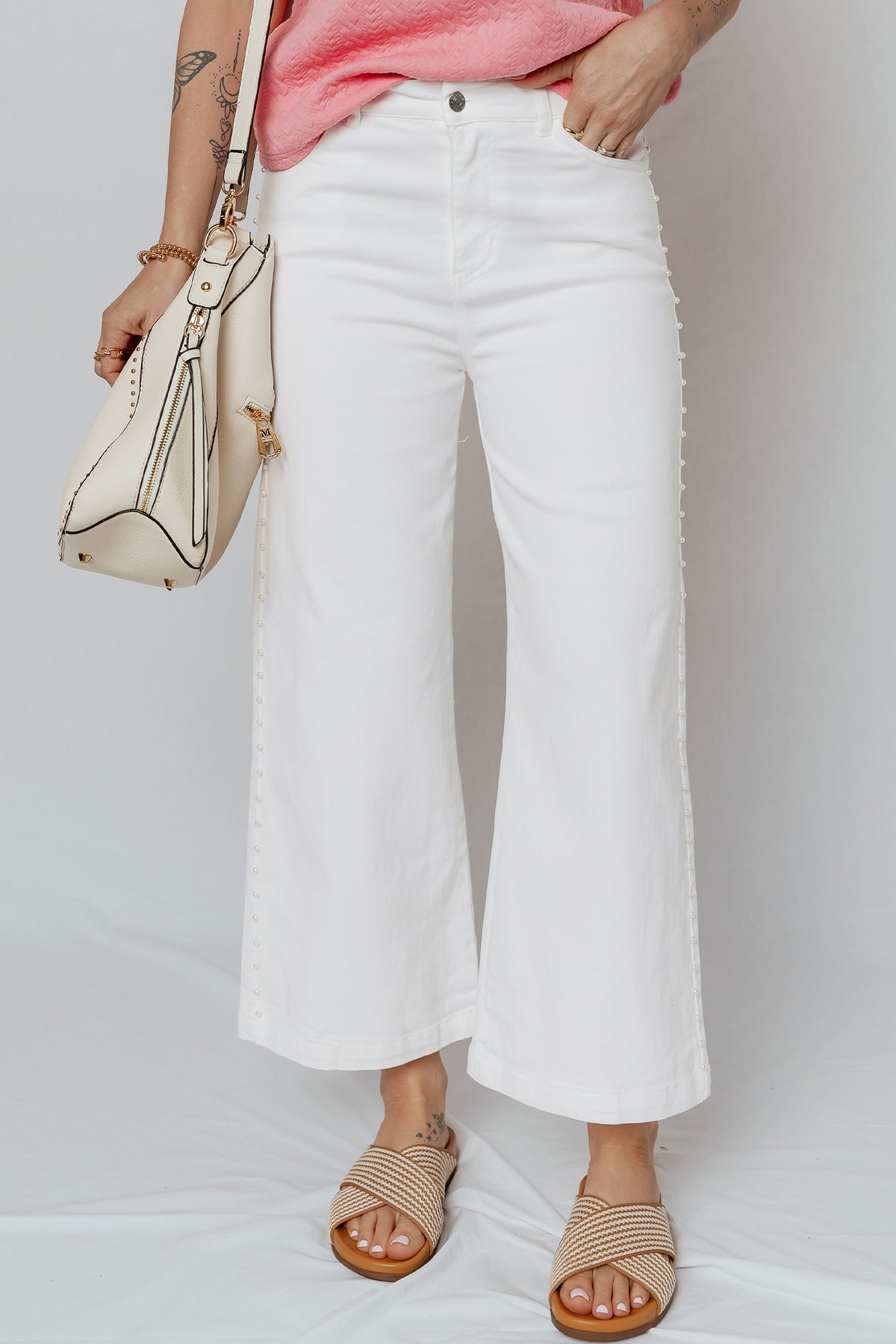 Close up of pearl beaded side seam on white jeans
