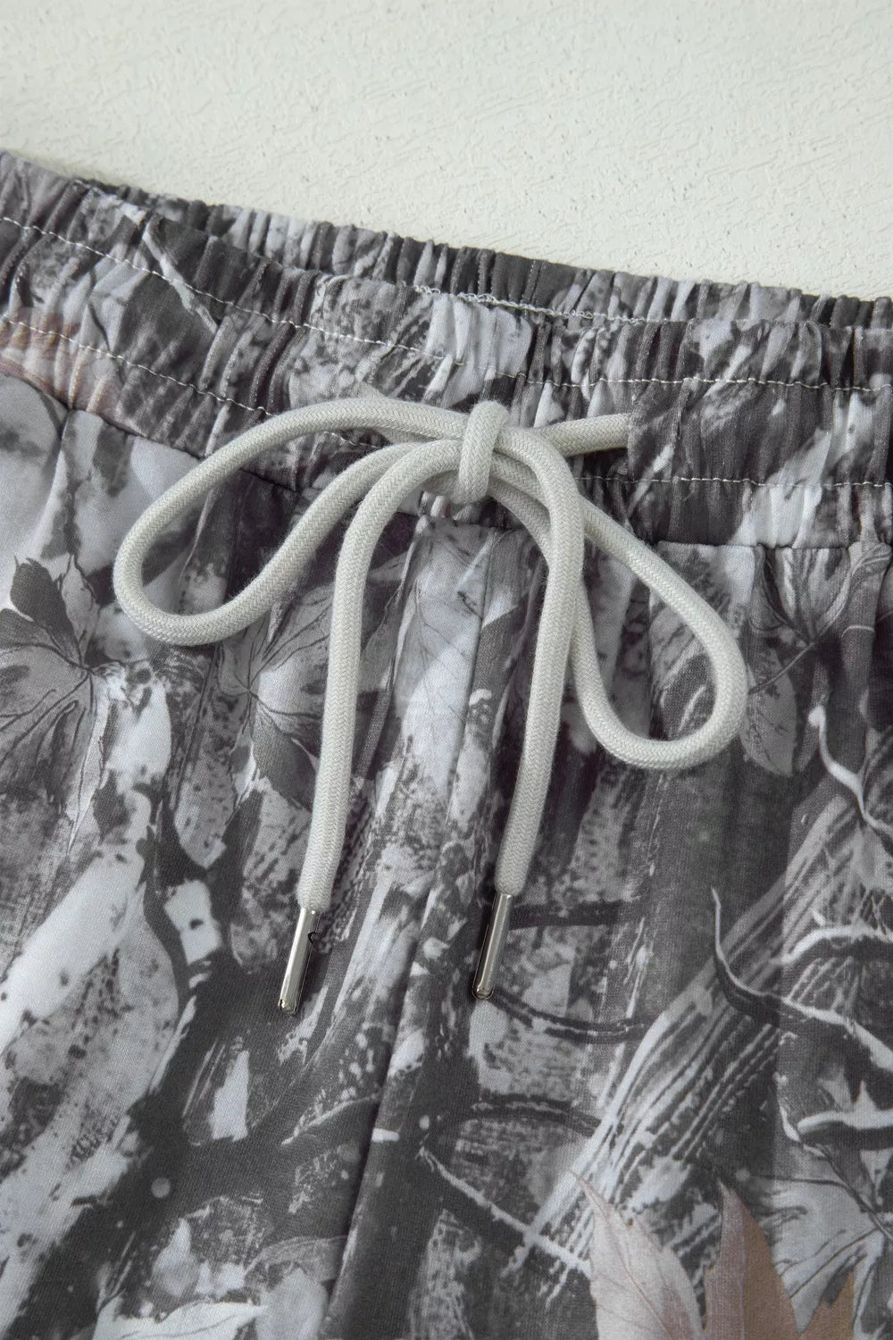 Grey abstract maple leaf print drawstring shorts fabric detail view