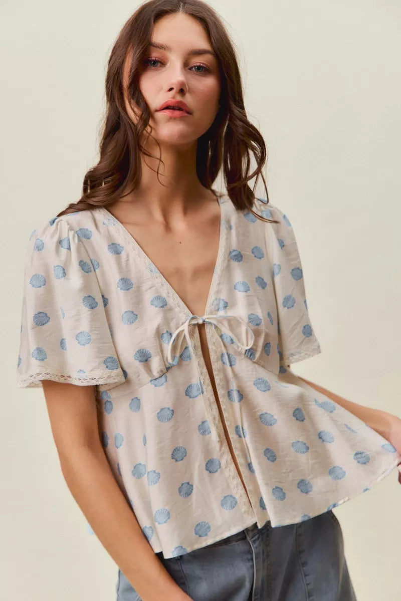 Ivory and blue shell print tie front flutter sleeve blouse styled view