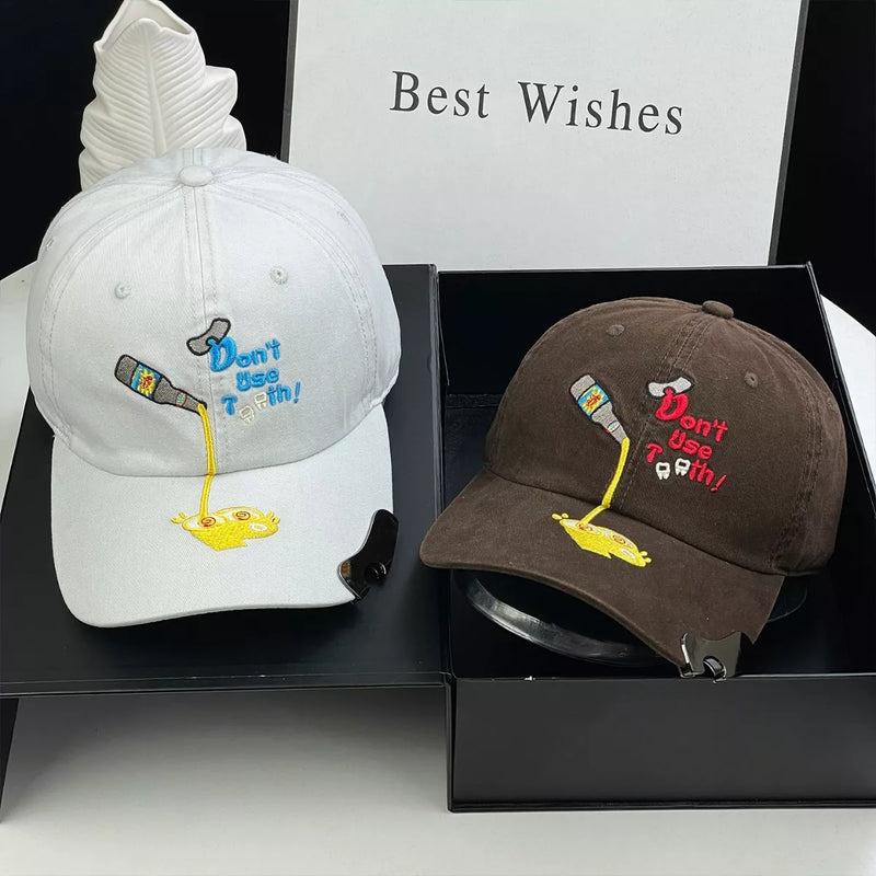 Cartoon embroidered baseball caps shown in white and brown with a gift box