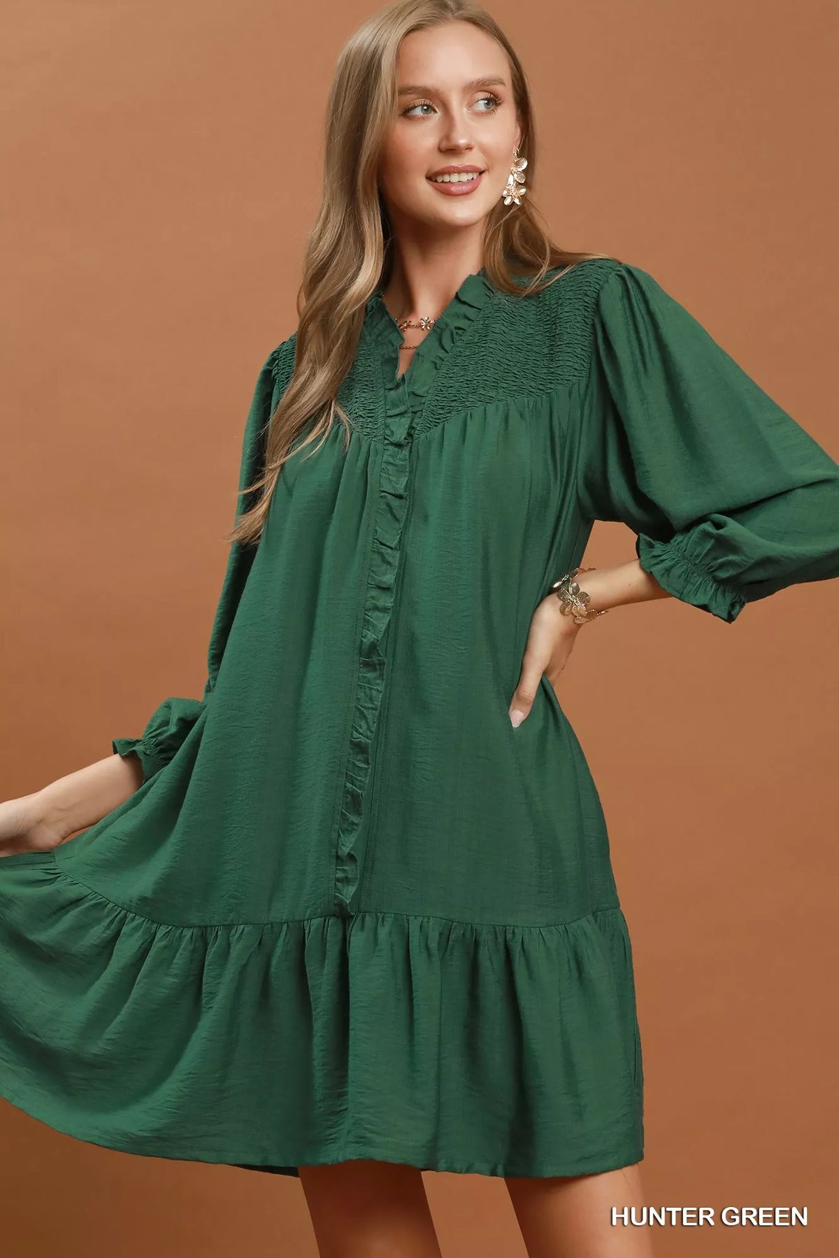 Hunter green smocked ruffle tiered mini dress on a model