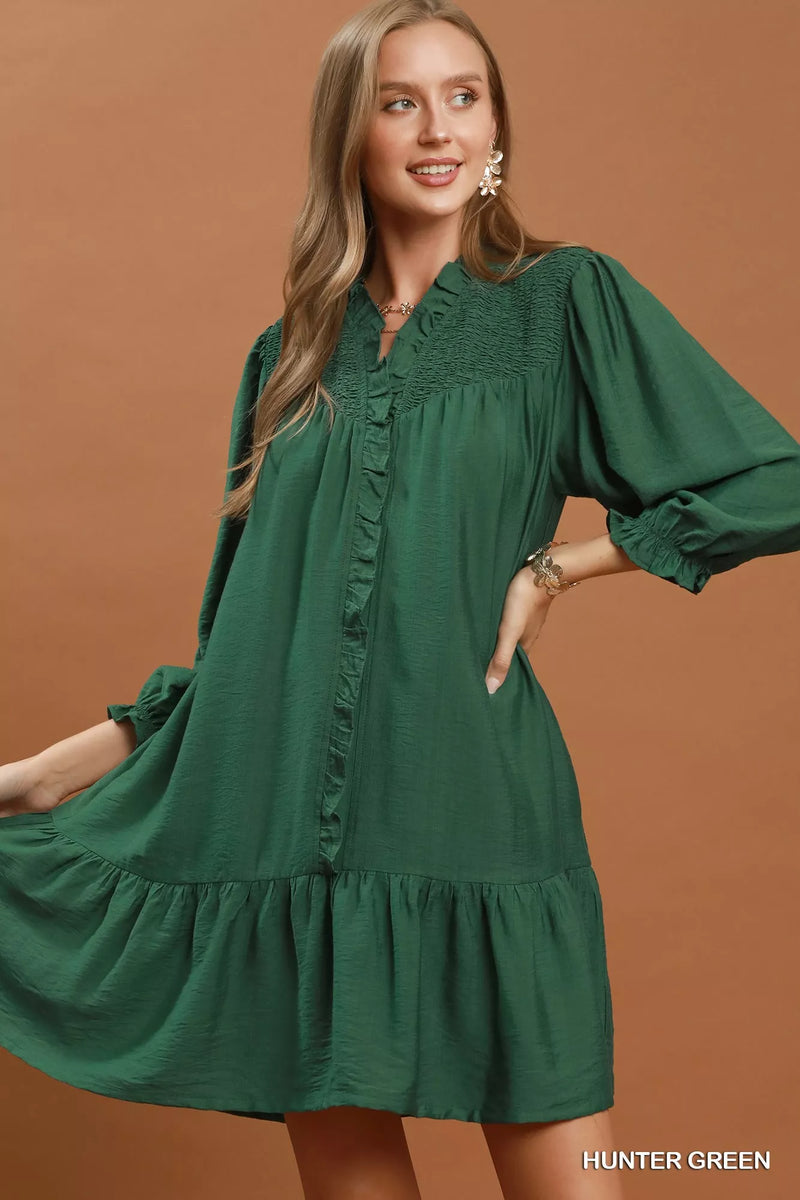 Hunter green smocked ruffle tiered mini dress on a model