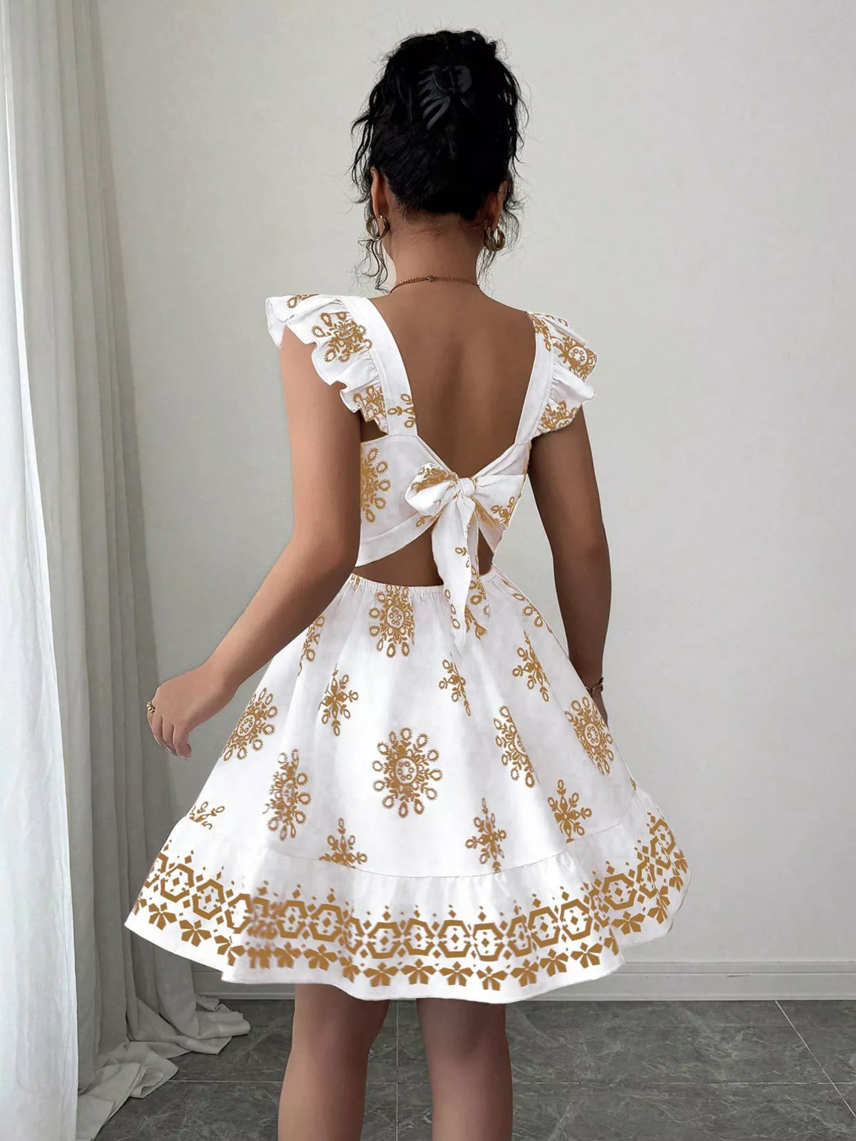 Bow back mini dress laid flat to show the cut
