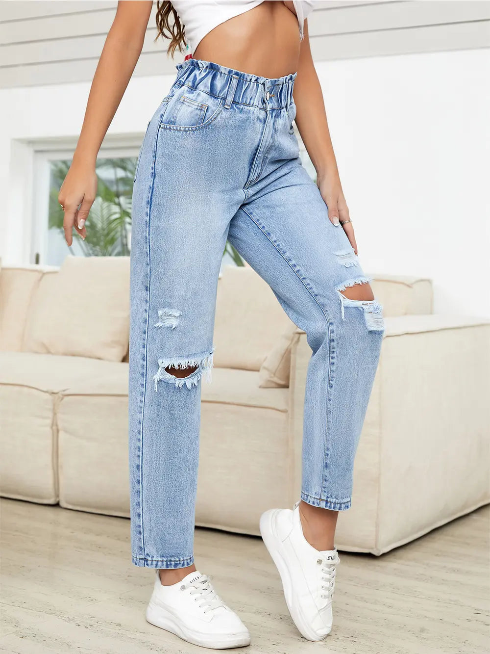 Distressing detail on light wash denim