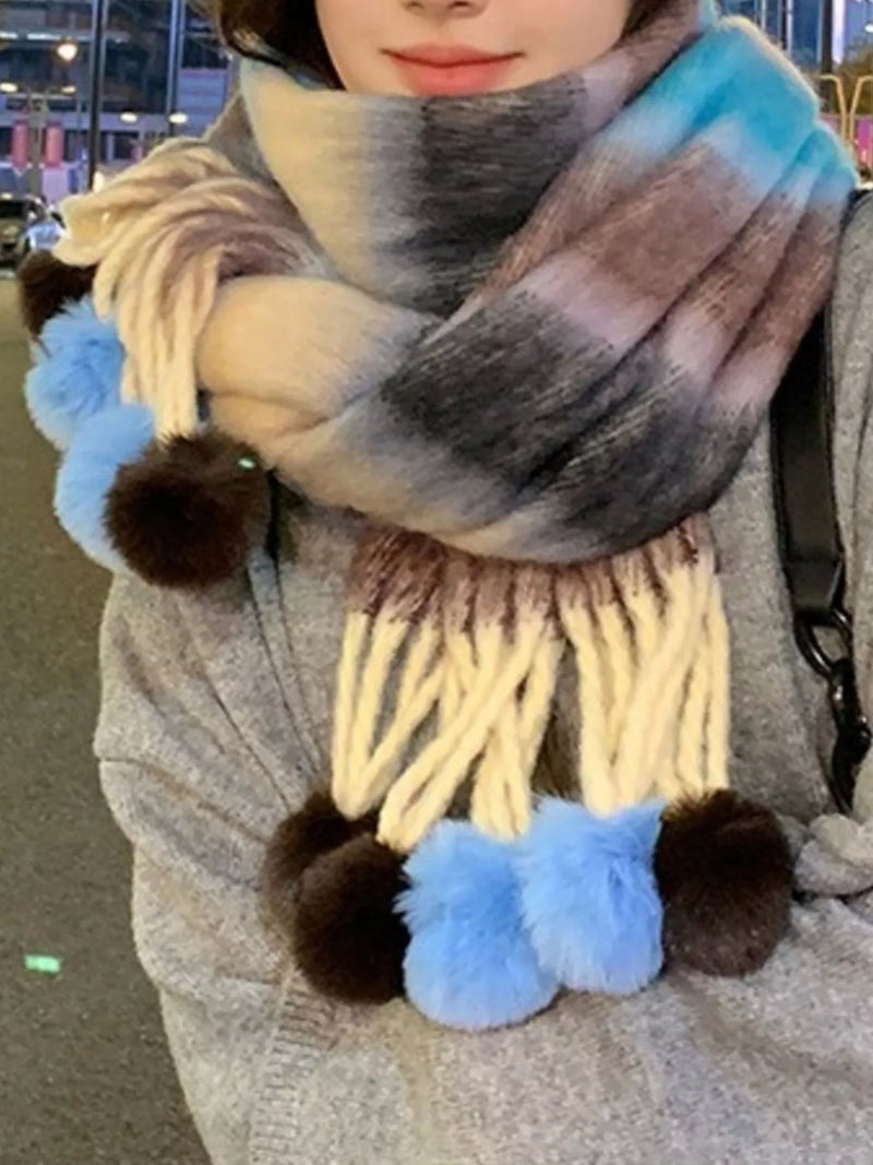 Striped scarf with pom poms shown around the neck