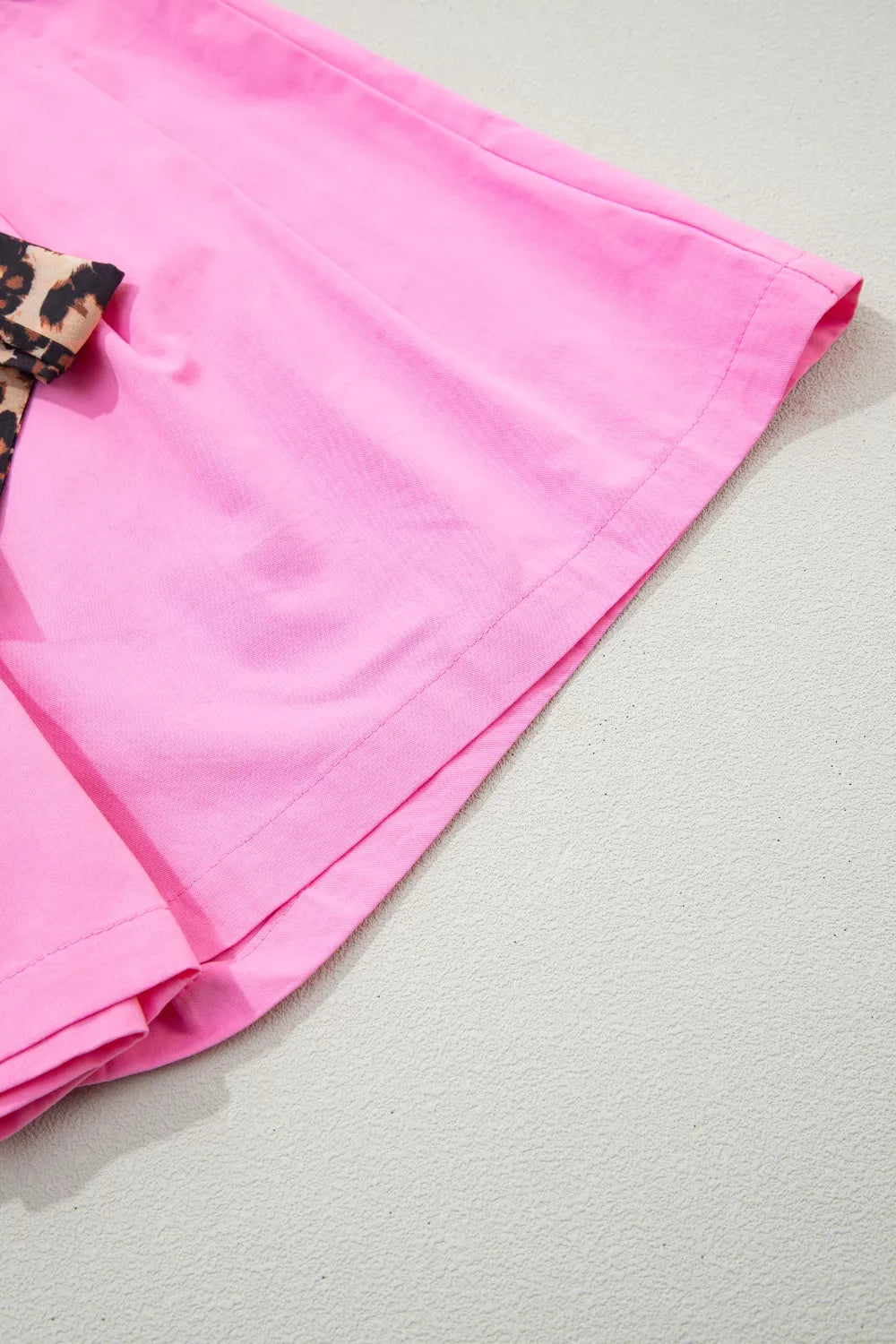 Fuchsia pink pleated wide leg shorts with leopard sash belt front view