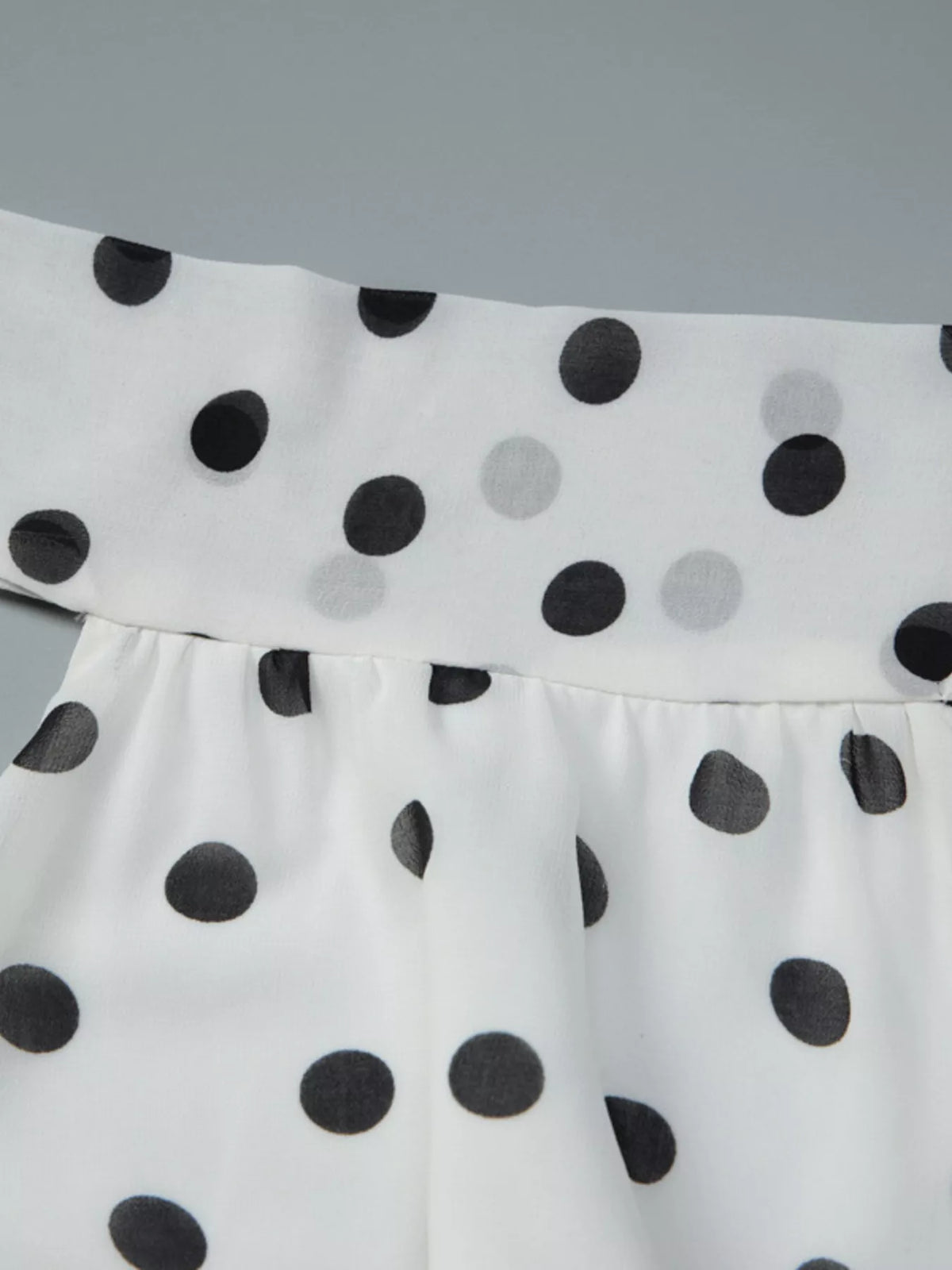 Polka dot halter dress shown with a straw bag