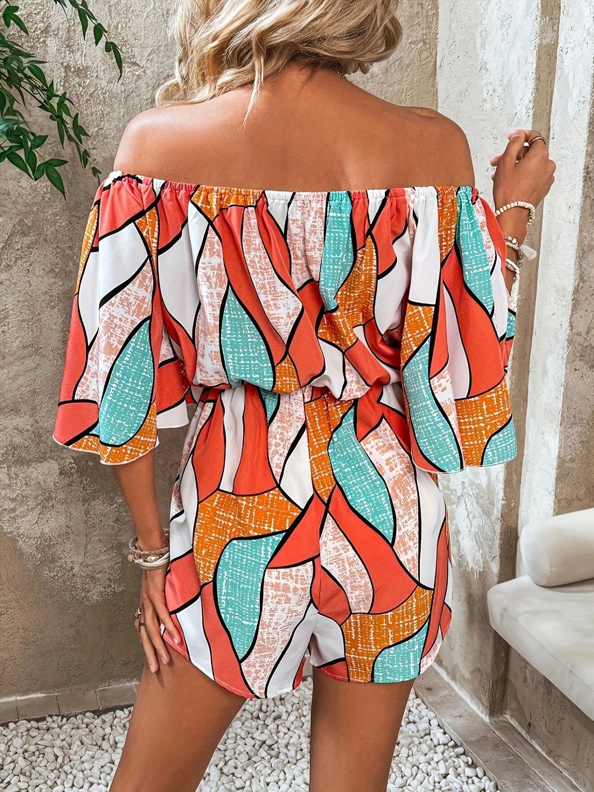 Off shoulder neckline detail on the orange romper