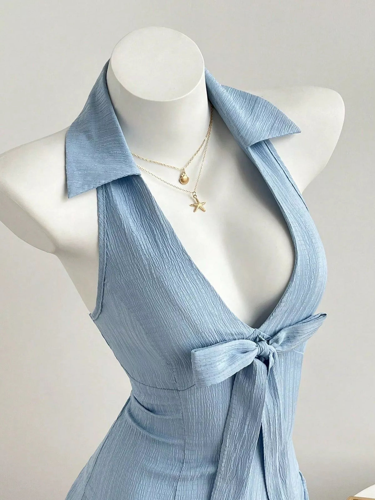 Close up of the bow on a light blue halter neck dress